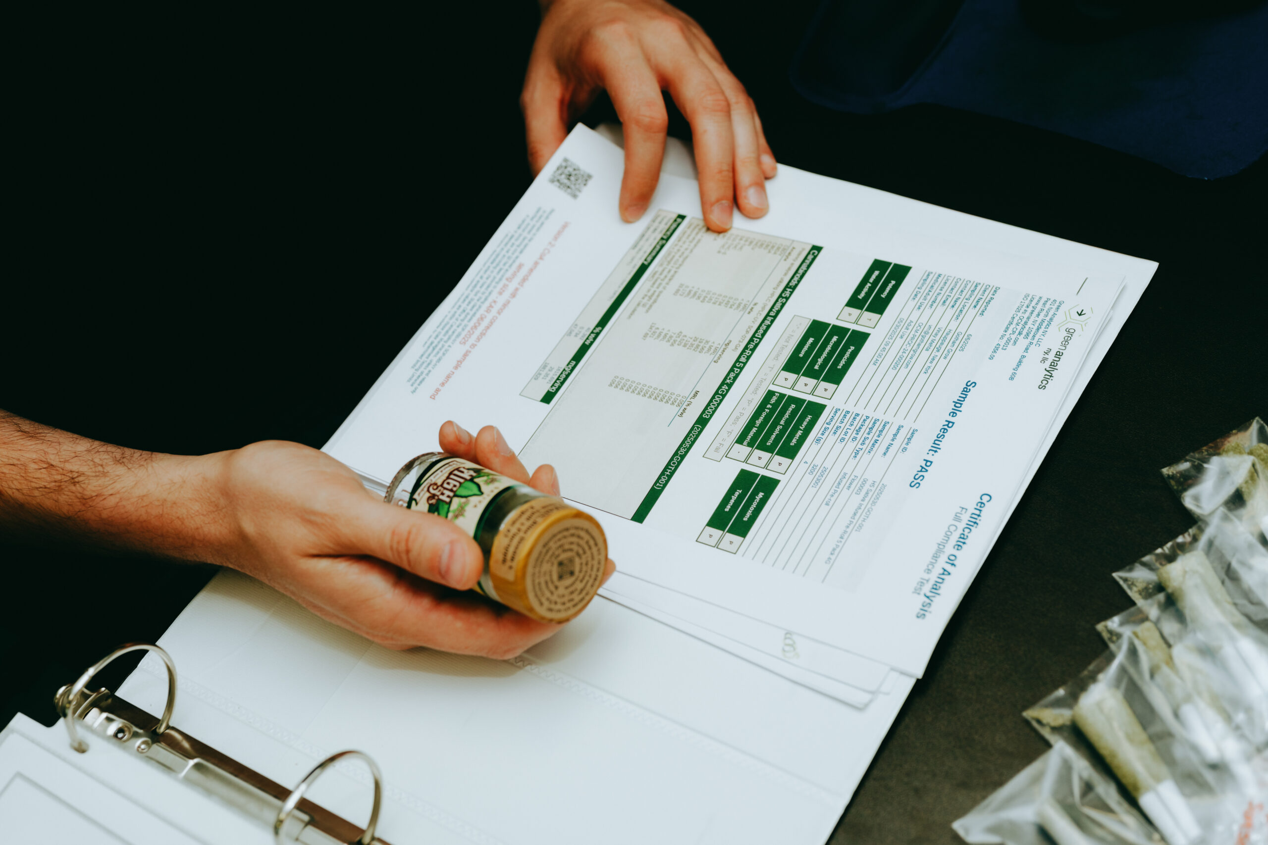 A High 5&rsquo;s Certificate of Analysis marked PASS, held next to the tested jar